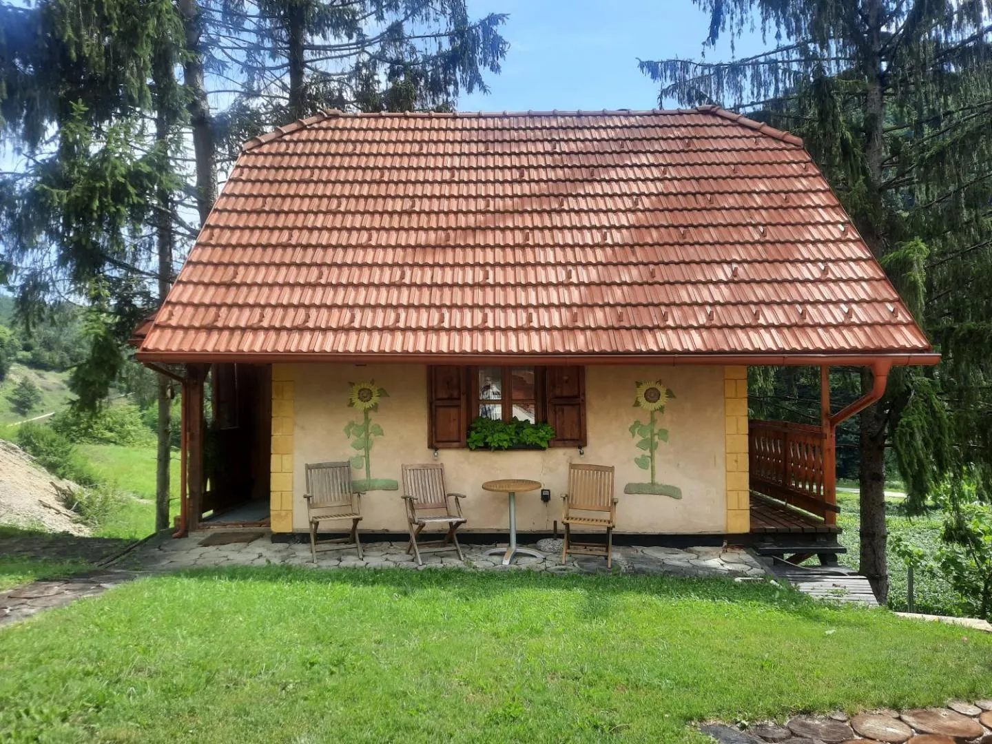 Zunanjost koče med drevesi.